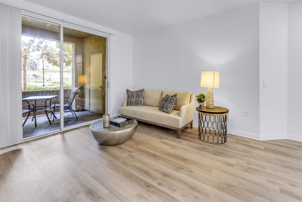 Spacious living room with modern decor and large windows in Legacy Apartments