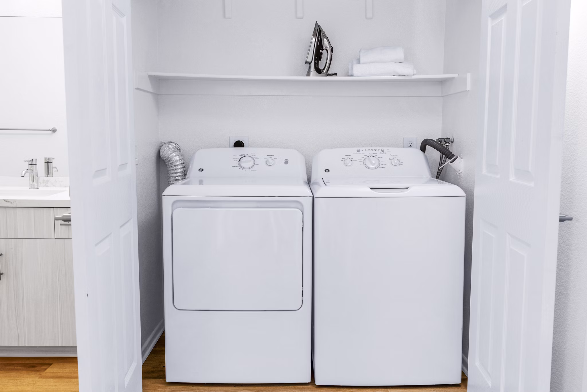Modern laundry room featuring high-efficiency washers and dryers in Legacy Apartments