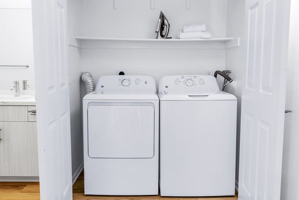 Modern laundry room featuring high-efficiency washers and dryers in Legacy Apartments