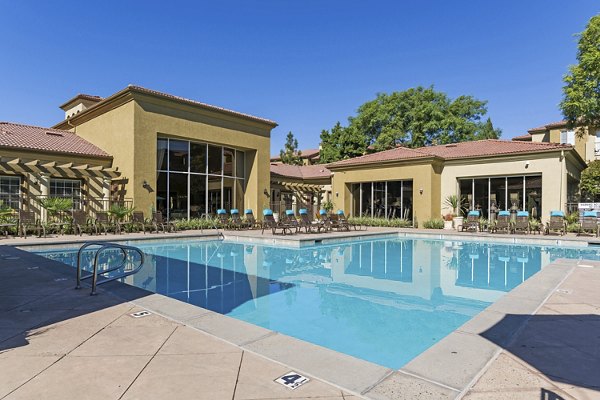 Rooftop pool with lounge seating at Legacy Apartments offering city views