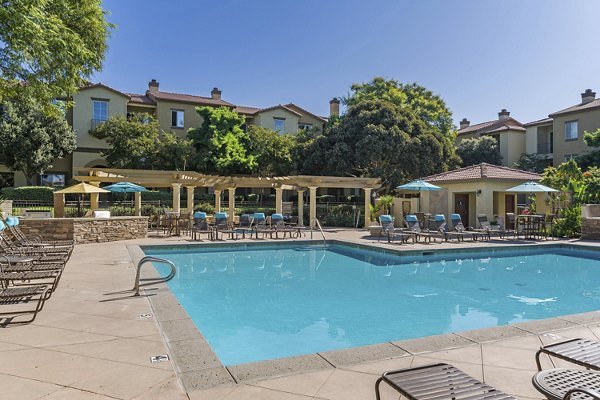 Expansive outdoor pool with lounge chairs at Legacy Apartments, offering relaxation and leisure in a luxury setting