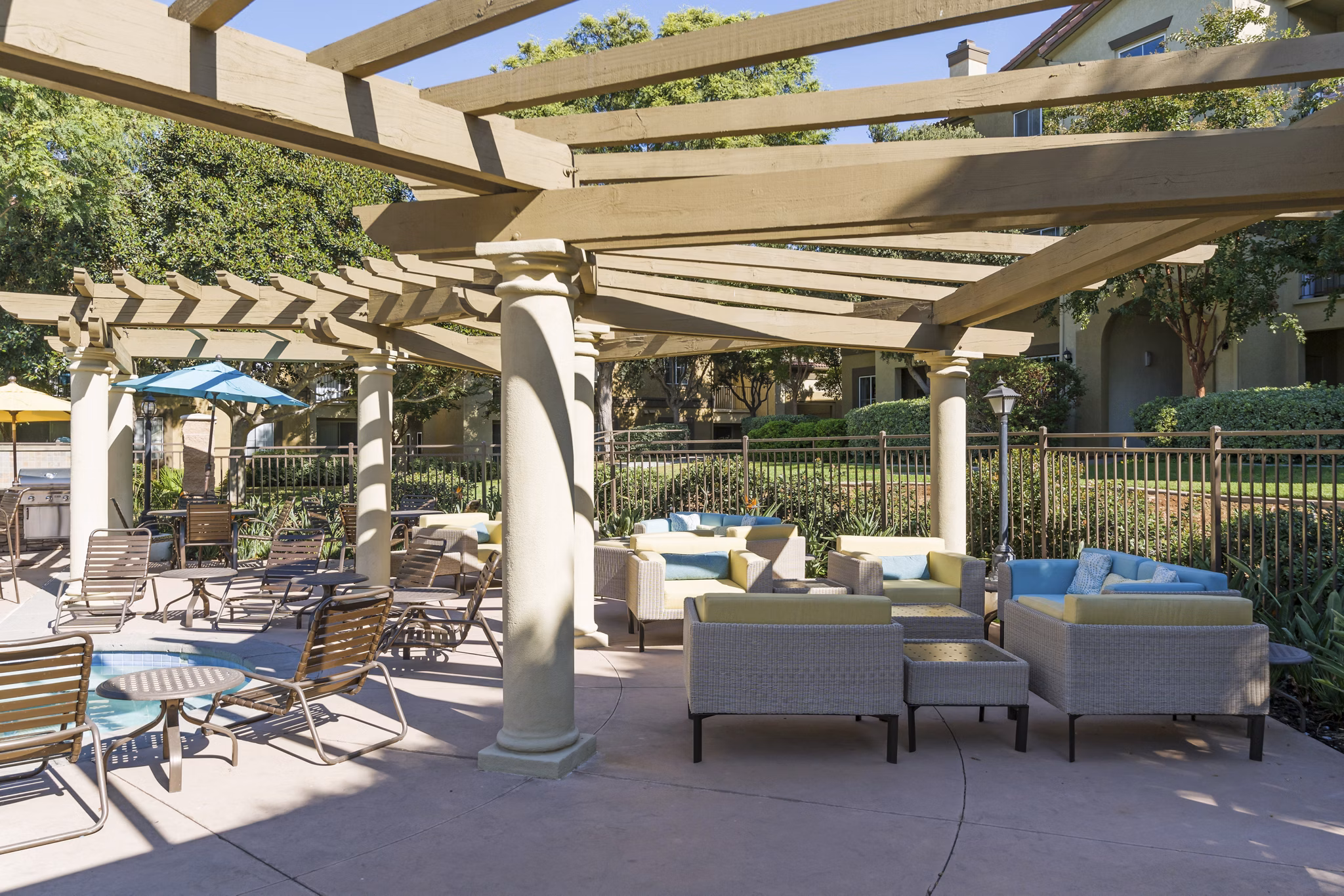 Cozy patio with modern seating, lush greenery at Legacy Apartments
