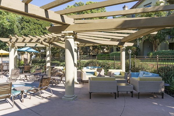 Cozy patio with modern seating, lush greenery at Legacy Apartments