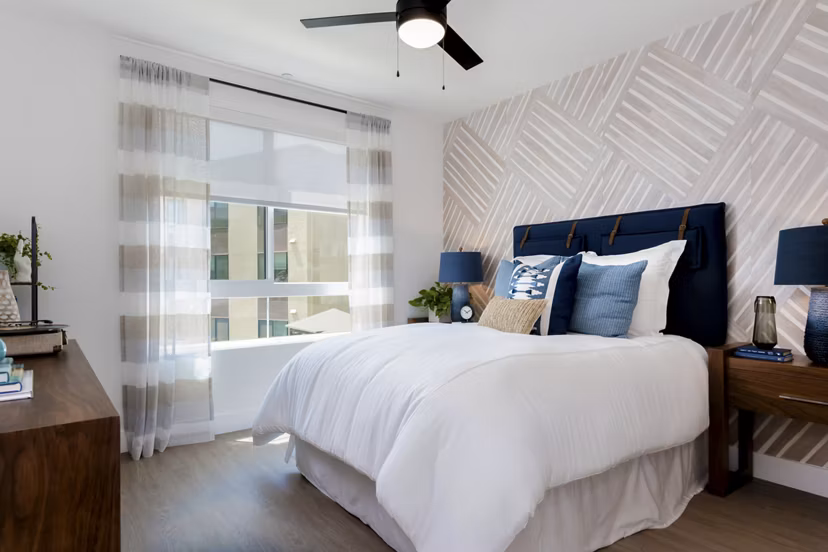 The Lofts at Carlsbad Village: Bright bedroom with modern furnishings and scenic views in luxury Carlsbad apartments