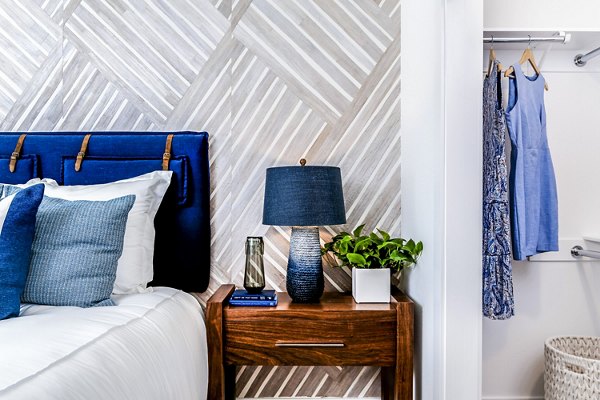 Cozy bedroom with modern decor at The Lofts at Carlsbad Village Apartments, featuring stylish furnishings and ample natural light