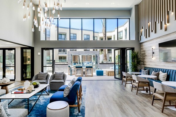 The Lofts at Carlsbad Village: Modern clubhouse lobby featuring sleek design and comfortable seating in luxury apartments