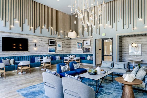 Elegant clubhouse lobby with modern decor at The Lofts at Carlsbad Village Apartments, featuring cozy seating and vibrant art pieces