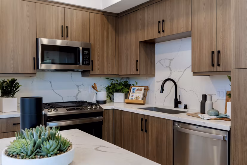 Kitchens with modern appliances and sleek countertops in The Lofts at Carlsbad Village Apartments