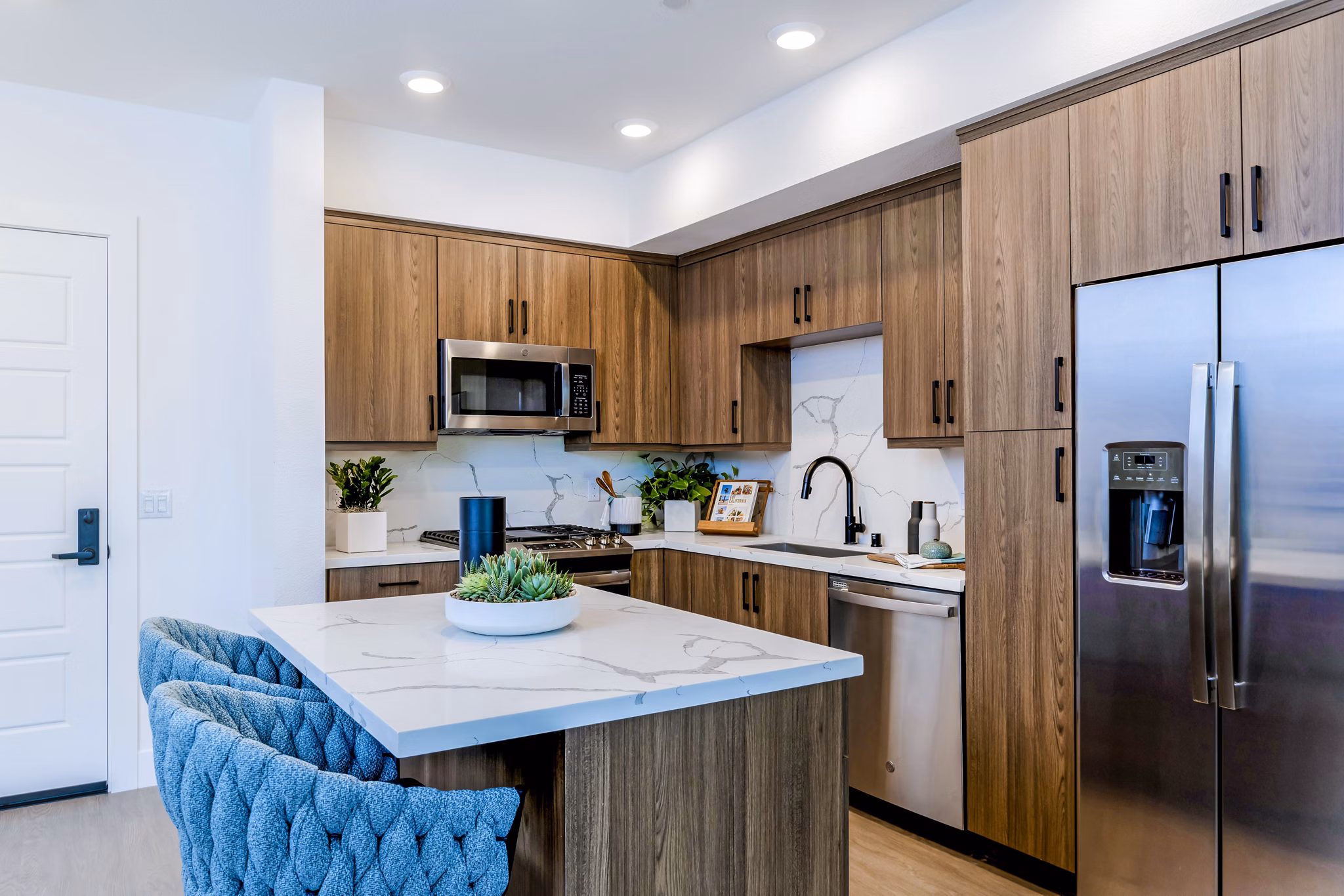 Kitchens with modern appliances and sleek countertops in The Lofts at Carlsbad Village Apartments