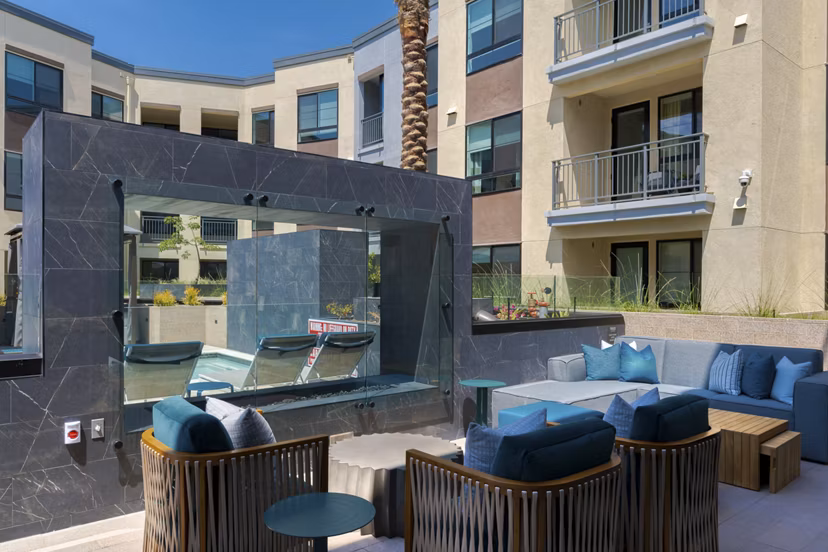 Modern patio with seating and greenery at The Lofts at Carlsbad Village Apartments