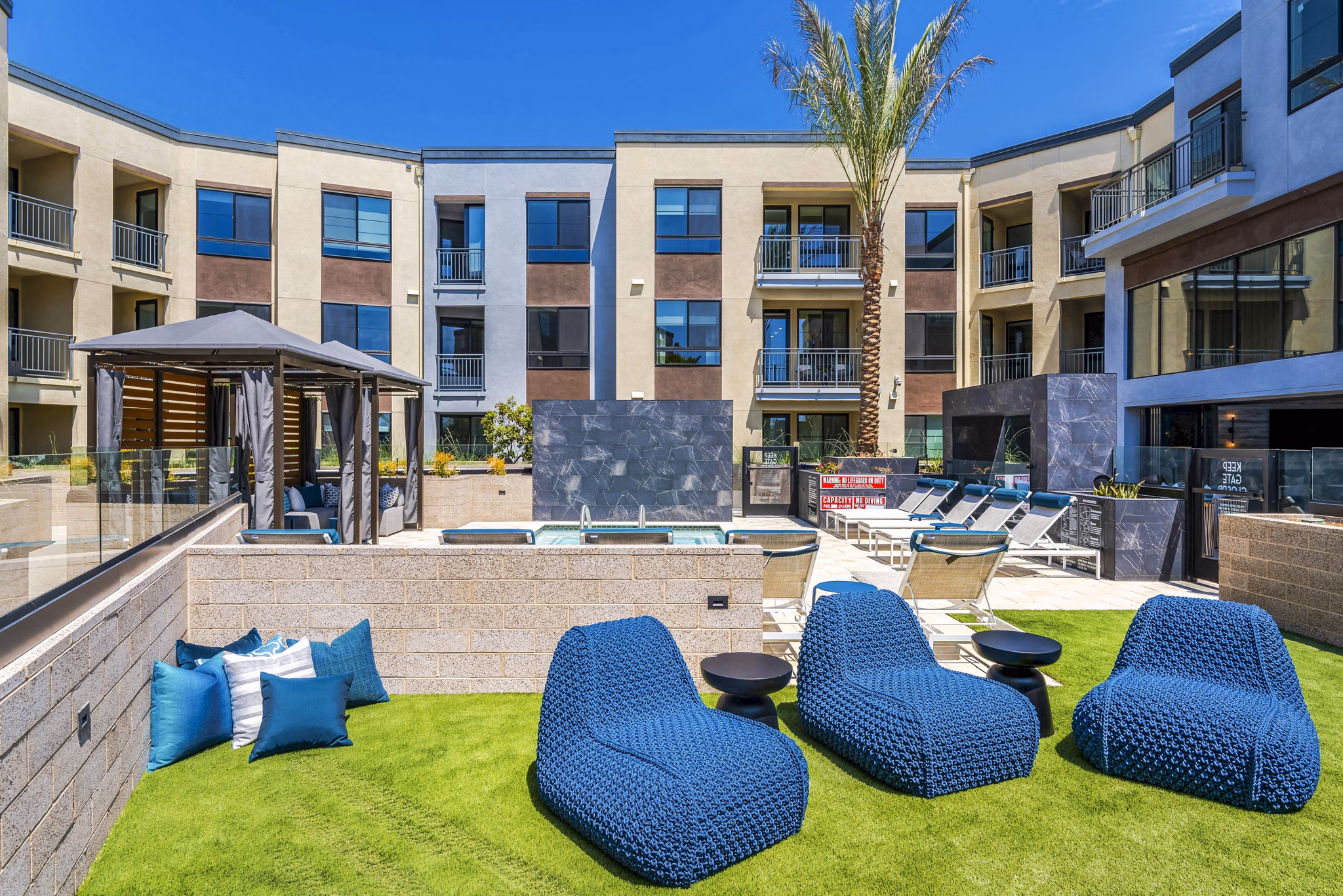 Modern patio with seating and greenery at The Lofts at Carlsbad Village Apartments