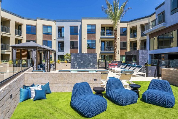 Modern patio with seating and greenery at The Lofts at Carlsbad Village Apartments