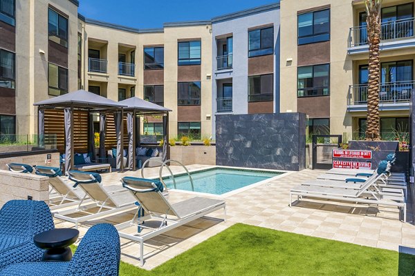 Resort-style pool with lounge seating at The Lofts at Carlsbad Village Apartments