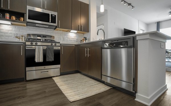 Modern kitchen featuring sleek appliances and granite countertops at Metro Mission Valley Apartments