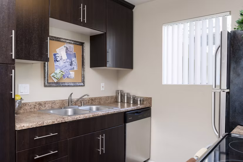 Modern kitchen featuring stainless steel appliances and granite countertops at Navajo Bluffs Apartments, Greystar luxury housing in San Diego
