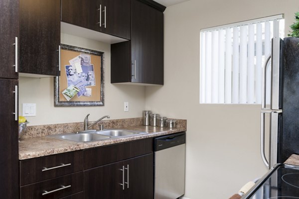 Modern kitchen featuring stainless steel appliances and granite countertops at Navajo Bluffs Apartments, Greystar luxury housing in San Diego