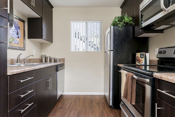 Modern kitchen with stainless steel appliances and granite countertops at Navajo Bluffs Apartments