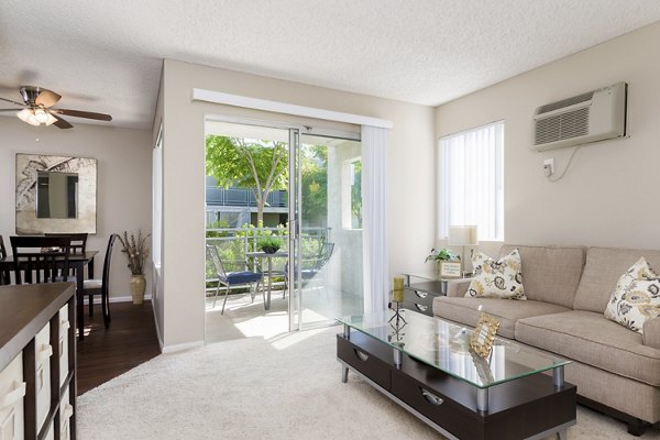 Contemporary living room with cozy seating and natural light at Navajo Bluffs Apartments