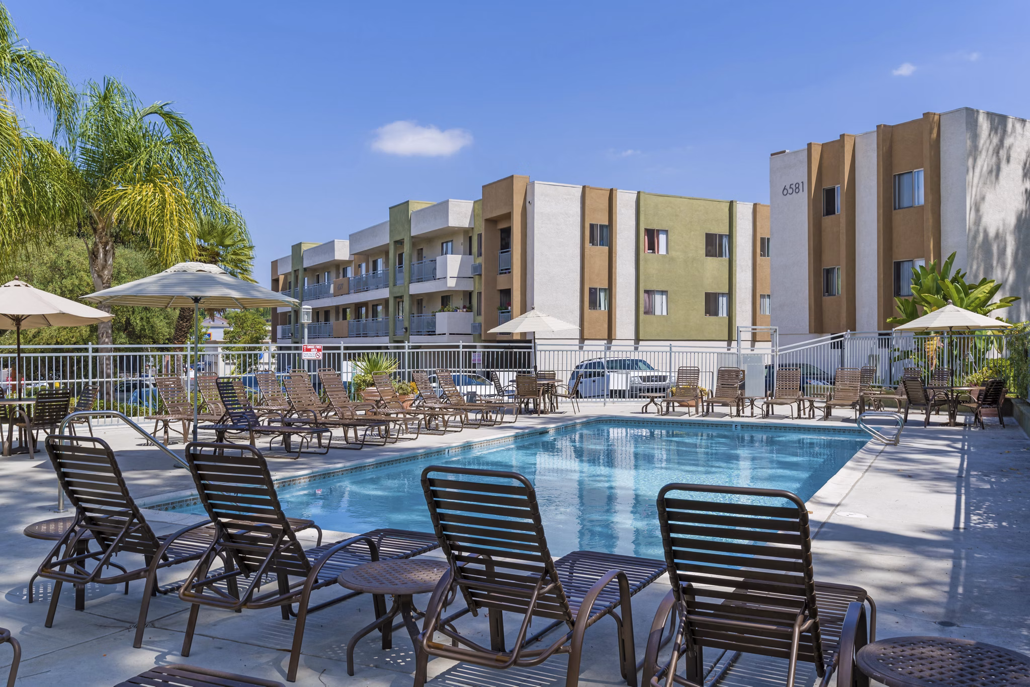 Relaxing outdoor pool at Navajo Bluffs Apartments with lush landscaping, ideal for unwinding and leisure activities