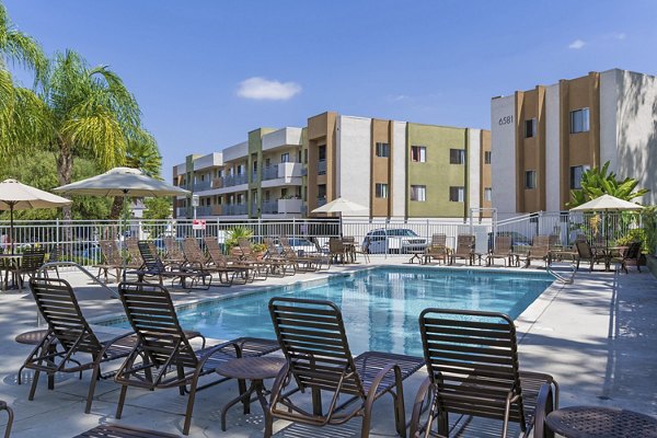 Relaxing outdoor pool at Navajo Bluffs Apartments with lush landscaping, ideal for unwinding and leisure activities