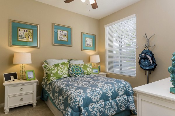 Bedroom with stylish decor and large windows at Riveredge Terrace Apartments, offering luxury living with modern amenities suitable for residents