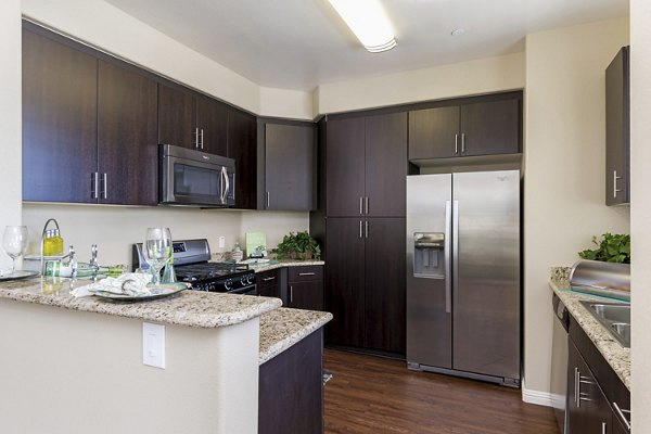 Modern kitchen featuring stainless steel appliances and granite countertops in Riveredge Terrace Apartments