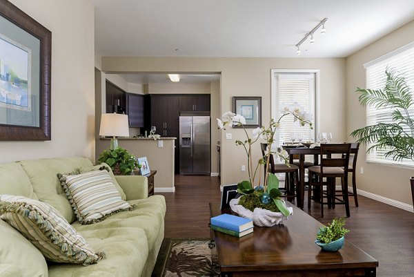 Spacious living room with modern decor at Riveredge Terrace Apartments, featuring cozy seating and large windows