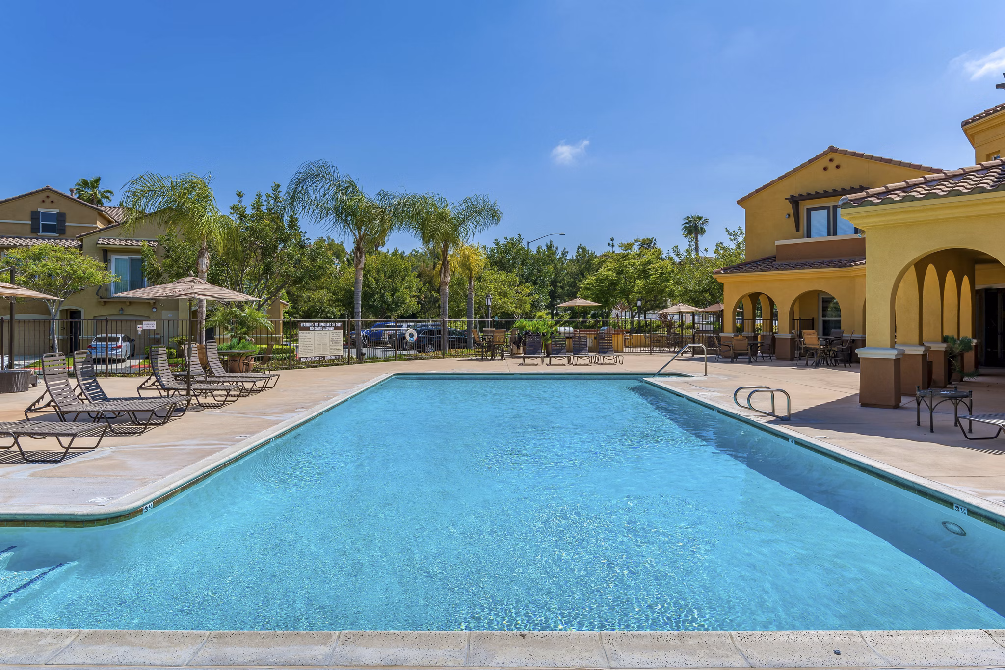 Relaxing outdoor pool with lounge chairs at Riveredge Terrace Apartments, luxurious living in serene surroundings