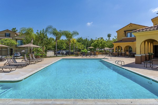 Relaxing outdoor pool with lounge chairs at Riveredge Terrace Apartments, luxurious living in serene surroundings