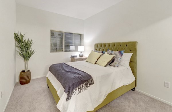 Bedroom featuring modern dÃ©cor and large windows at Parc One Apartments, luxury living spaces by Greystar