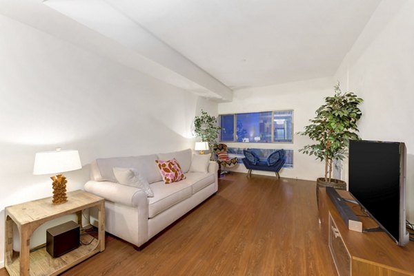 Spacious living room with modern decor and large windows at Parc One Apartments