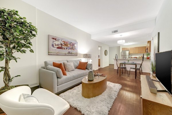Modern living room featuring sleek furnishings and large windows at Parc One Apartments