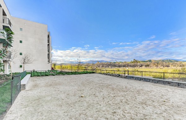 Fenced dog park with agility equipment at Parc One Apartments, offering a pet-friendly environment for residents and their furry companions