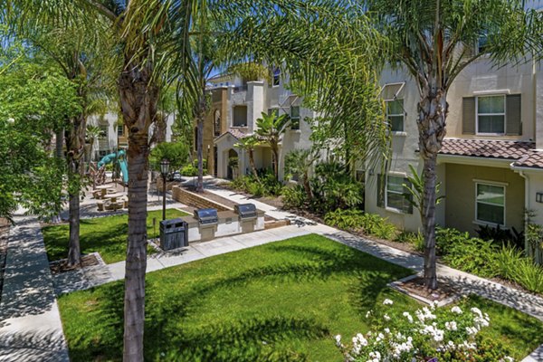 Grill area and courtyard with lush landscaping at Rosina Vista Apartments in Chula Vista, enhancing outdoor relaxation and socializing spaces