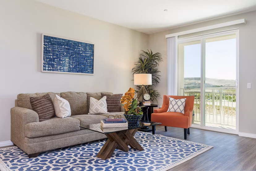 Modern living room with cozy seating and large windows at Salerno Apartments