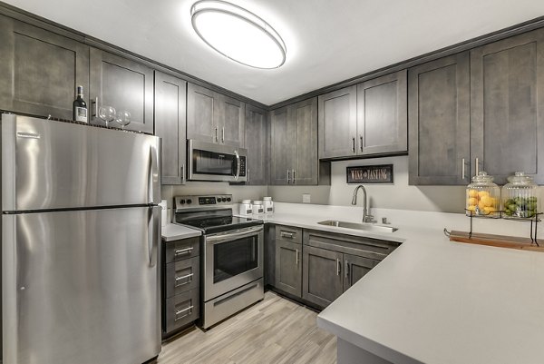 Modern kitchen with stainless steel appliances in Santee Villas Apartments featuring open layout and granite countertops