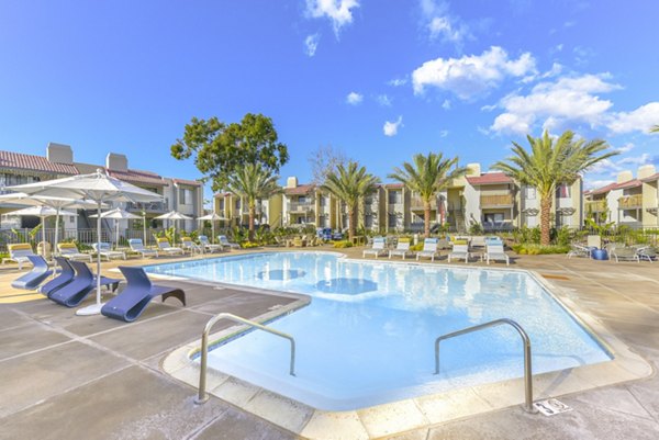 Resort-style pool area with lounge chairs at Santee Villas Apartments