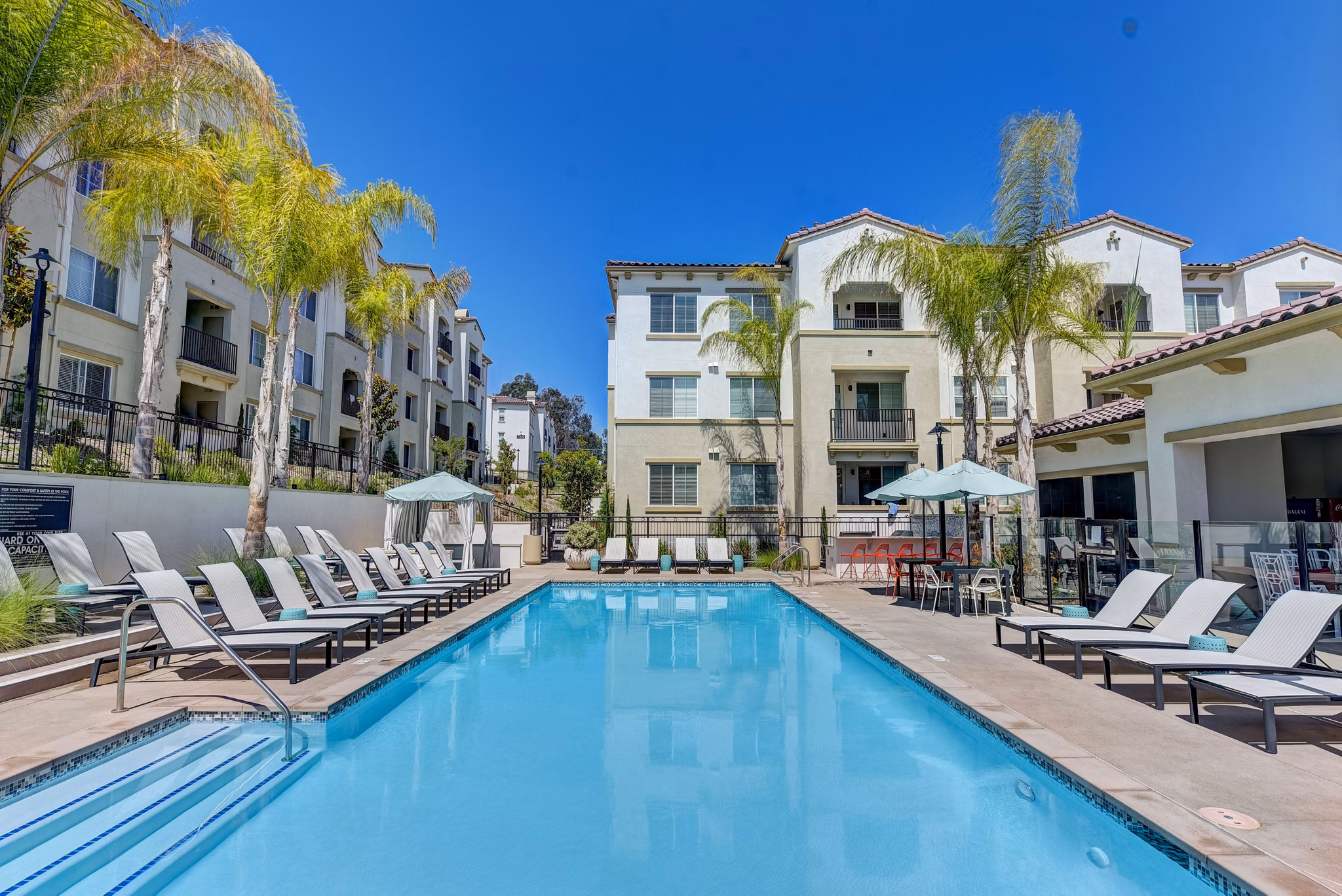 Outdoor pool area with sun loungers at Seta Apartments, luxurious living in a serene setting