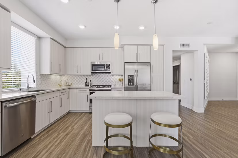 Modern kitchen featuring stainless steel appliances and quartz countertops in Sola at Pacific Highlands Ranch Apartments