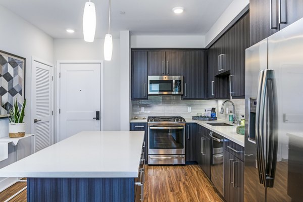 Modern kitchen featuring stainless steel appliances and quartz countertops in Sola at Pacific Highlands Ranch Apartments