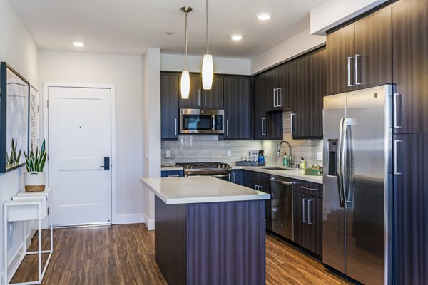 Modern kitchen with stainless steel appliances at Sola at Pacific Highlands Ranch Apartments