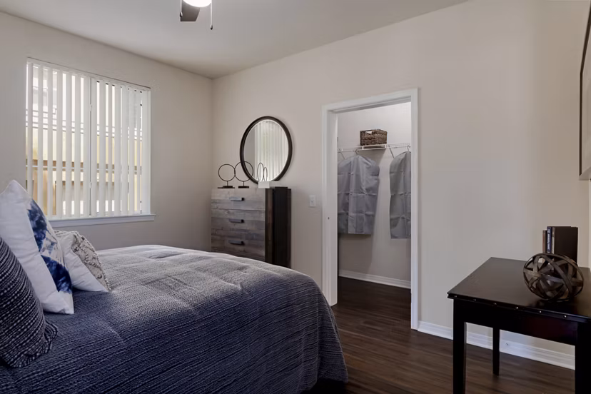 Cozy bedroom with large windows at Missions at Sunbow Apartments offering luxury living in a serene setting