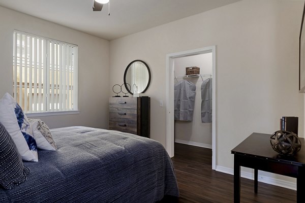 Cozy bedroom with large windows at Missions at Sunbow Apartments offering luxury living in a serene setting