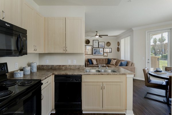Modern kitchen with stainless steel appliances and granite countertops at Missions at Sunbow Apartments