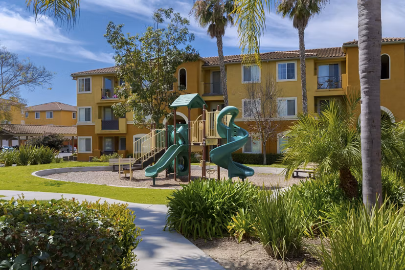 Playground at Missions at Sunbow Apartments featuring colorful slides and swings in Chula Vista Perfect for family-friendly outdoor fun