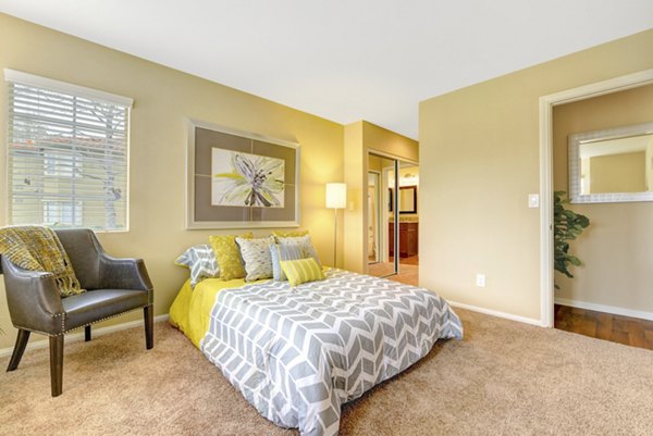 Cozy bedroom with contemporary decor at Sunbow Villas Apartments, featuring luxurious bedding and ample natural light