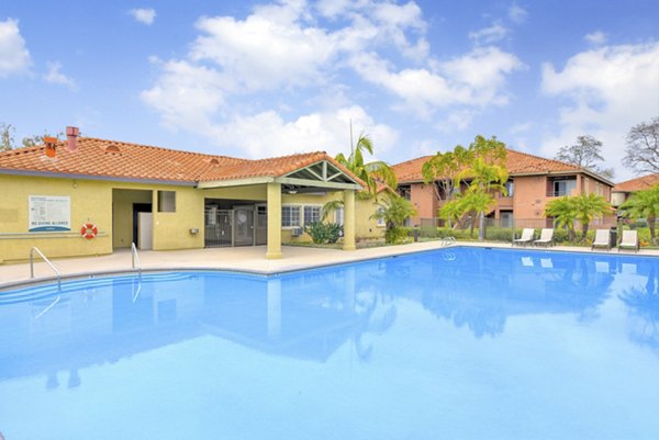 Relaxing pool area with sun loungers at Sunbow Villas Apartments offering modern luxury living