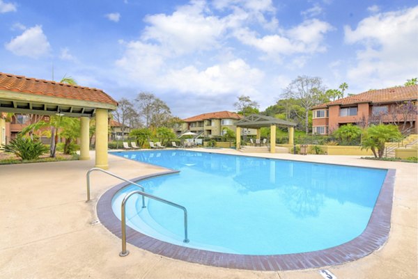 Relaxing pool area with lush greenery at Sunbow Villas Apartments, perfect for luxury living in a serene environment