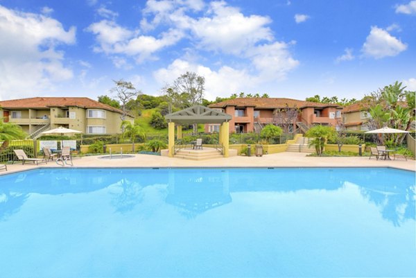 Relaxing pool area with lounge chairs at Sunbow Villas Apartments