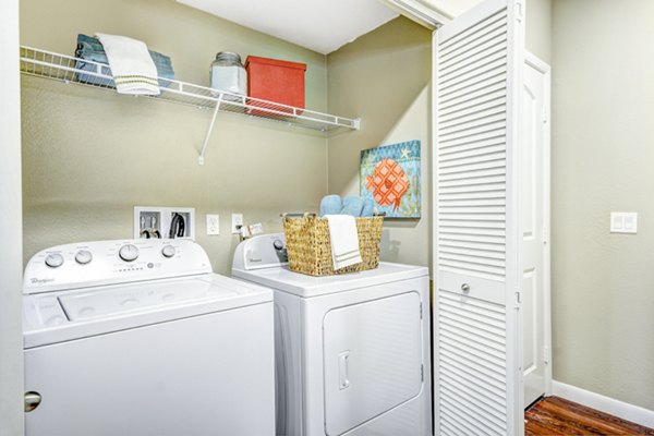 Modern laundry room featuring high-efficiency washers and dryers at Tavera Apartments